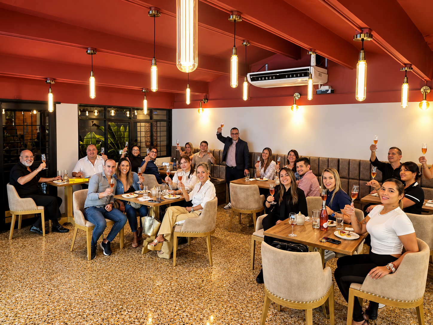 Grupo de asistentes en restaurante con copas levantadas