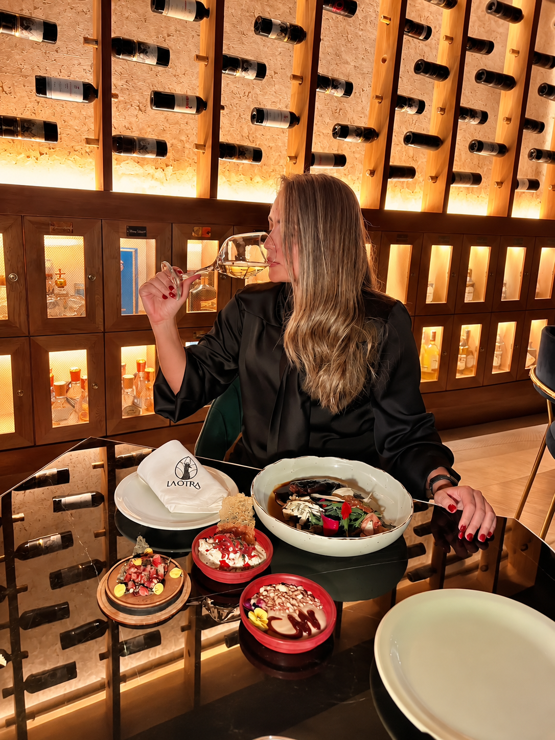 Luisa Sommelier degustando un vino frente a la cava